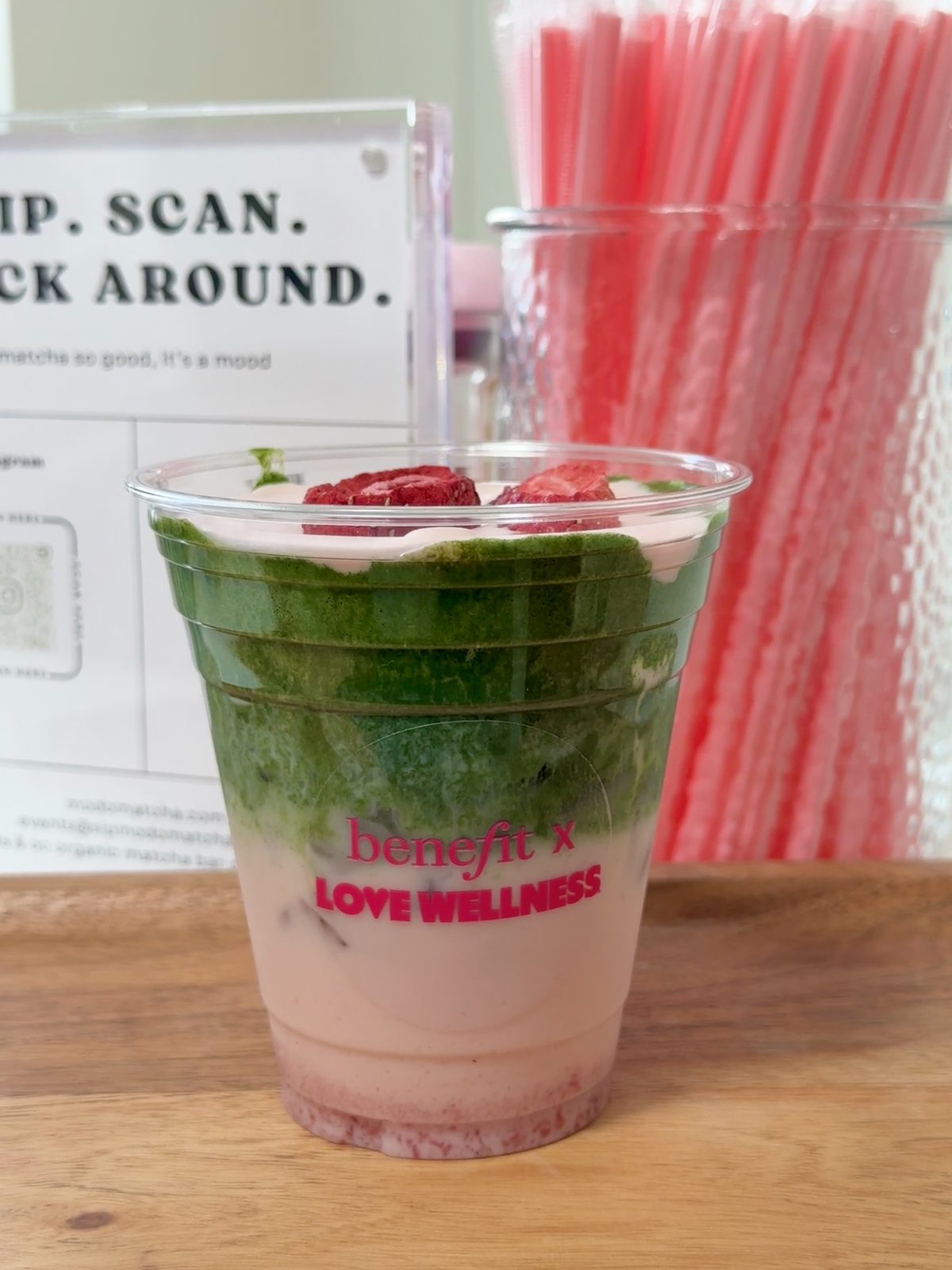 Layered strawberry matcha in a co-branded Benefit x Love Wellness cup with freeze-dried strawberries