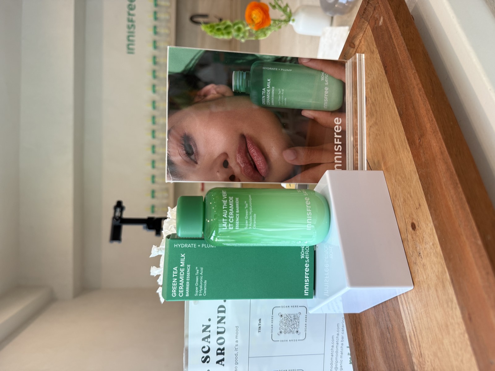 Innisfree Green Tea Ceramide Milk beside Modo Matcha's Sip Scan Stick Around signage at the Beverly Grove, Los Angeles activation