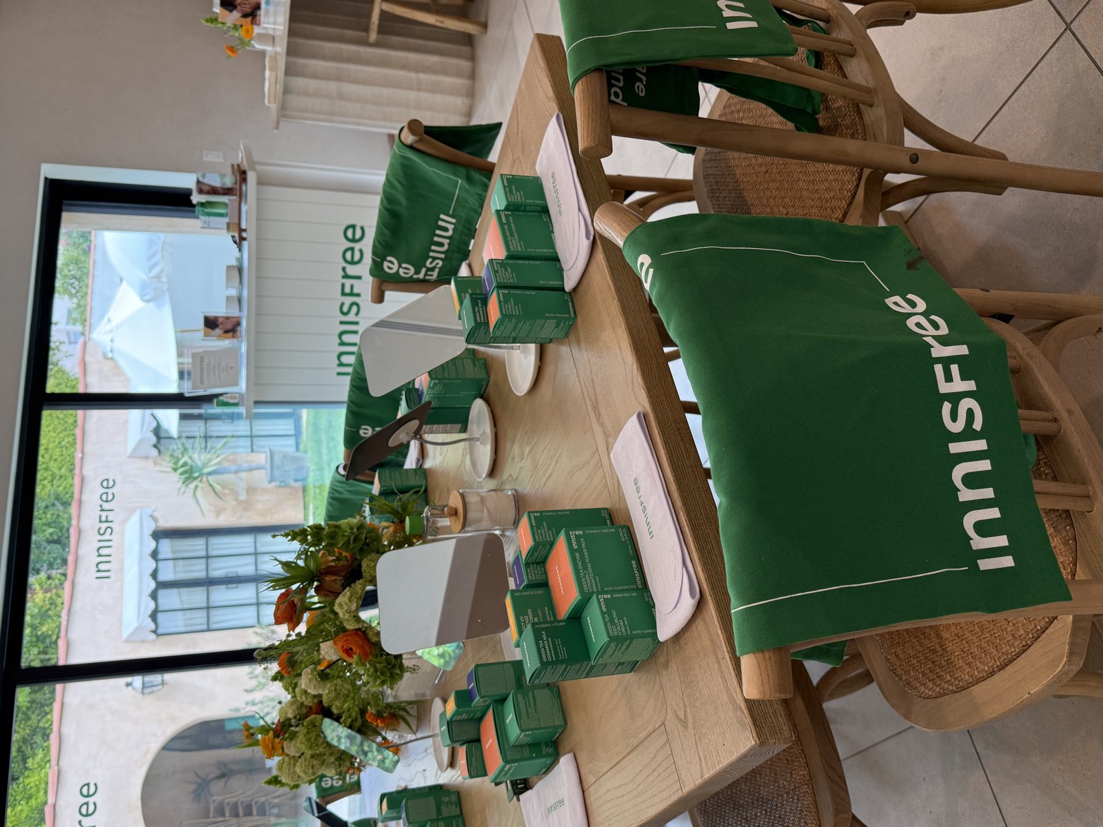 Innisfree branded masterclass table set with green tea skincare boxes and florals in Beverly Grove, Los Angeles