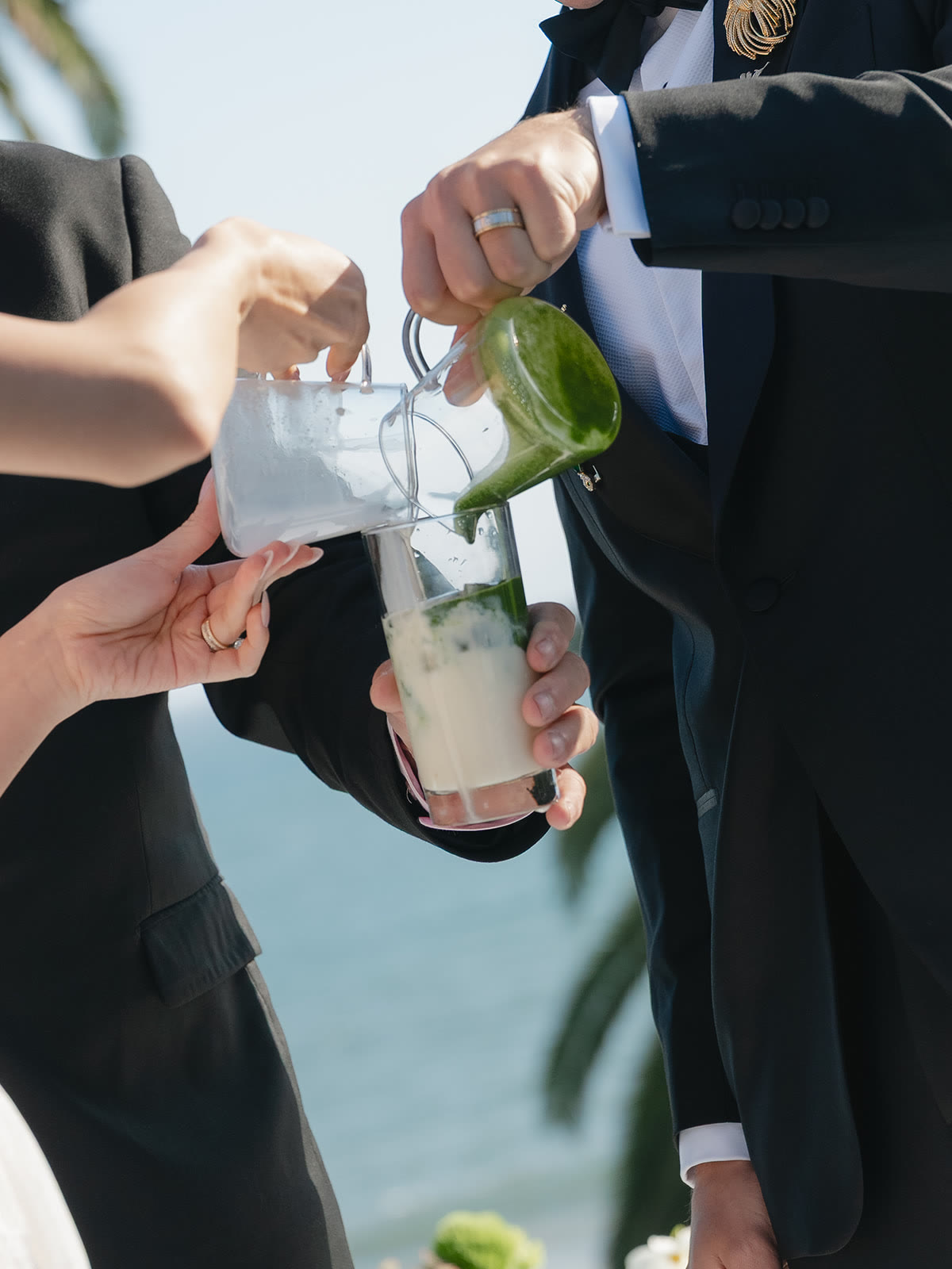 A shared matcha pour during the wedding vows, matcha and milk meeting in one glass